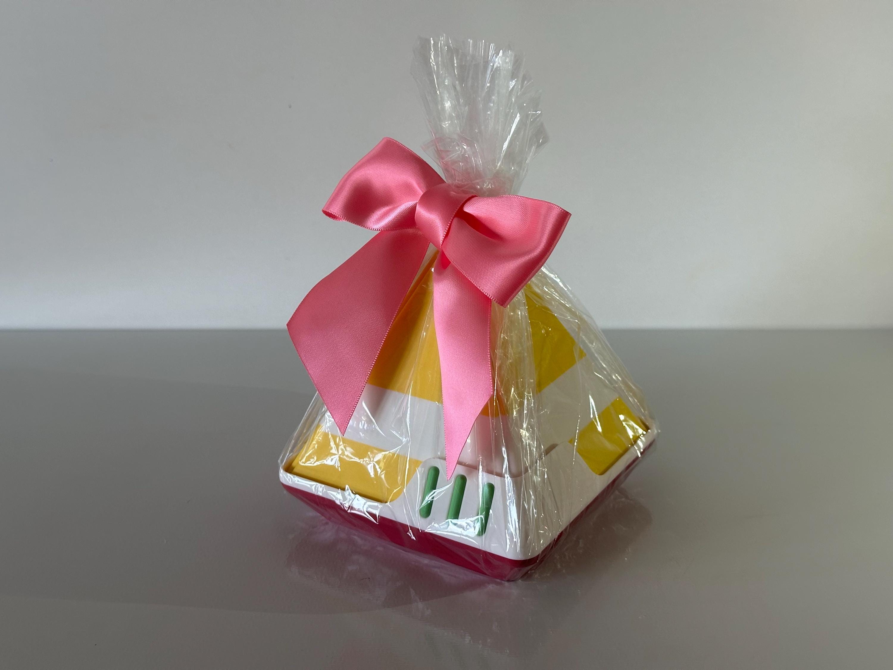 Gift bag with pink ribbon on a gray surface